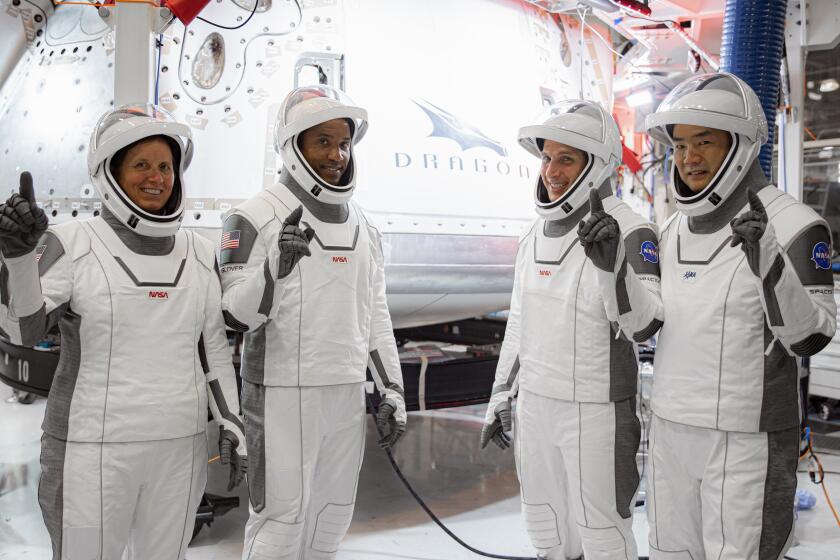 In this Thursday, Sept. 24, 2020, image released by SpaceX/NASA, NASA’s SpaceX Crew-1 astronauts, from left, mission specialist Shannon Walker, pilot Victor Glover, and Crew Dragon commander Michael Hopkins, all NASA astronauts, and mission specialist Soichi Noguchi, Japan Aerospace Exploration Agency (JAXA) astronaut, gesture during crew equipment interface testing at SpaceX headquarters in Hawthorne, Calif. SpaceX’s second astronaut flight is off until mid-November 2020 because red lacquer dripped into tiny vent holes in two rocket engines that now must be replaced. (SpaceX/NASA via AP)