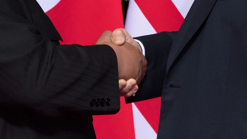 President Trump, right, and North Korean leader Kim Jong Un shake hands at the start of their summit in Singapore on Tuesday.