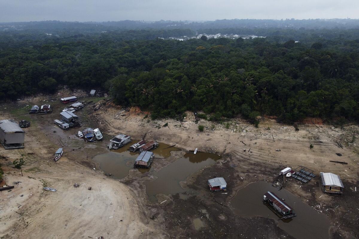 Embarcaciones y casas flotantes encalladas en una zona seca del río Negro durante una sequía, el lunes 16 de octubre de 2023, en Manaos, en el estado de Amazonas, Brasil. (AP Foto/Edmar Barros)