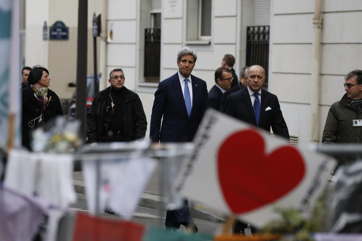 U.S. Secretary of State John F. Kerry, center, and French Foreign Minister Laurent Fabius arrive at the Charlie Hebdo offices in Paris on Jan. 16 to honor the victims of last week's terror attack.