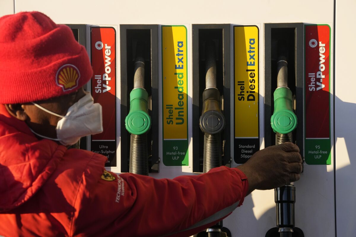 A petrol pump attendant replaces a pump at a filling station in Soweto, South Africa, Tuesday, May 31, 2022. South Africans are feeling the bite of fuel price increases that are blamed on Russia's war in Ukraine and the rise in the Brent crude oil price. (AP Photo/Themba Hadebe)