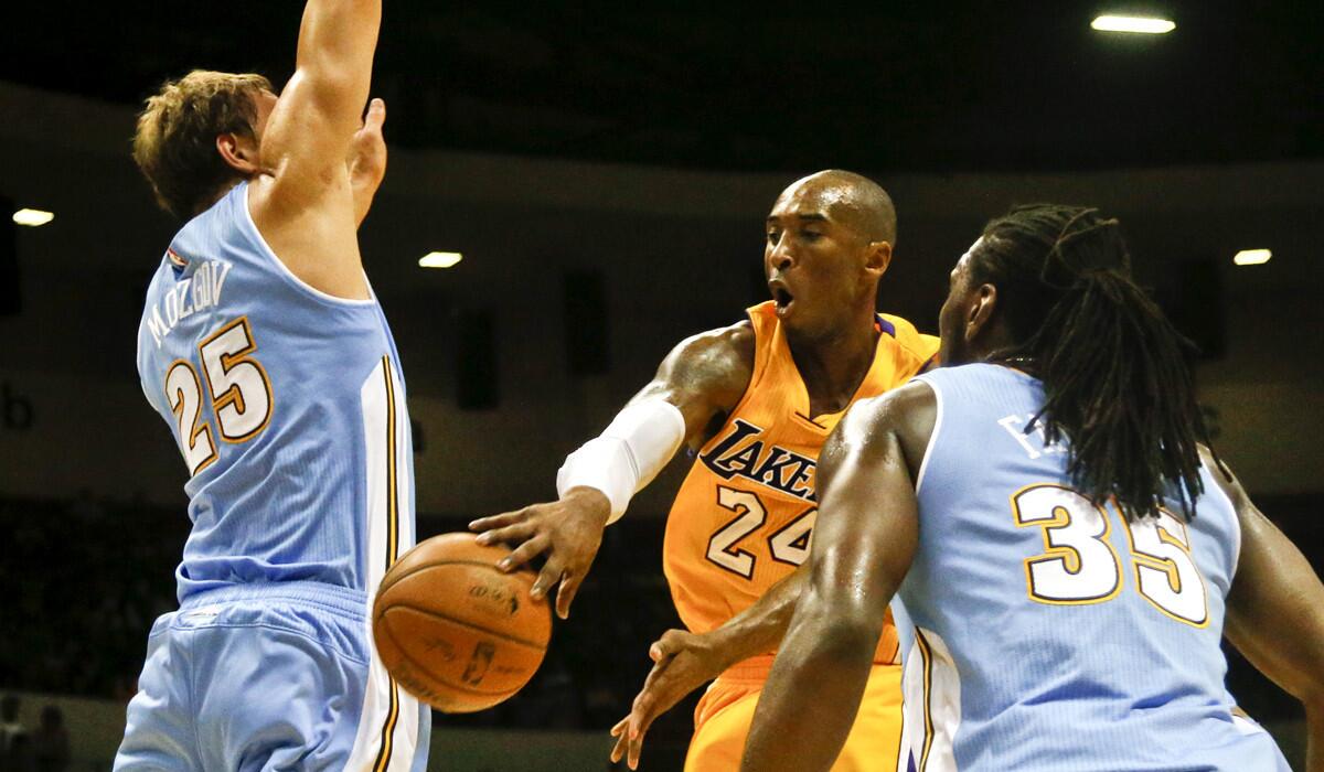 Lakers guard Kobe Bryant makes a wrap-around pass against Nuggets center Timofey Mozgov (25) during a preseason game.