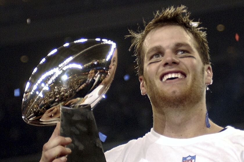 FILE - In this Feb. 1, 2004, file photo, New England Patriots quarterback Tom Brady holds the Vince Lombardi Trophy after the Patriots beat the Carolina Panthers 32-29 in Super Bowl 38 in Houston. Brady, who won a record seven Super Bowls for New England and Tampa, has announced his retirement, Wednesday, Feb. 1, 2023. (AP Photo/Dave Martin, File)