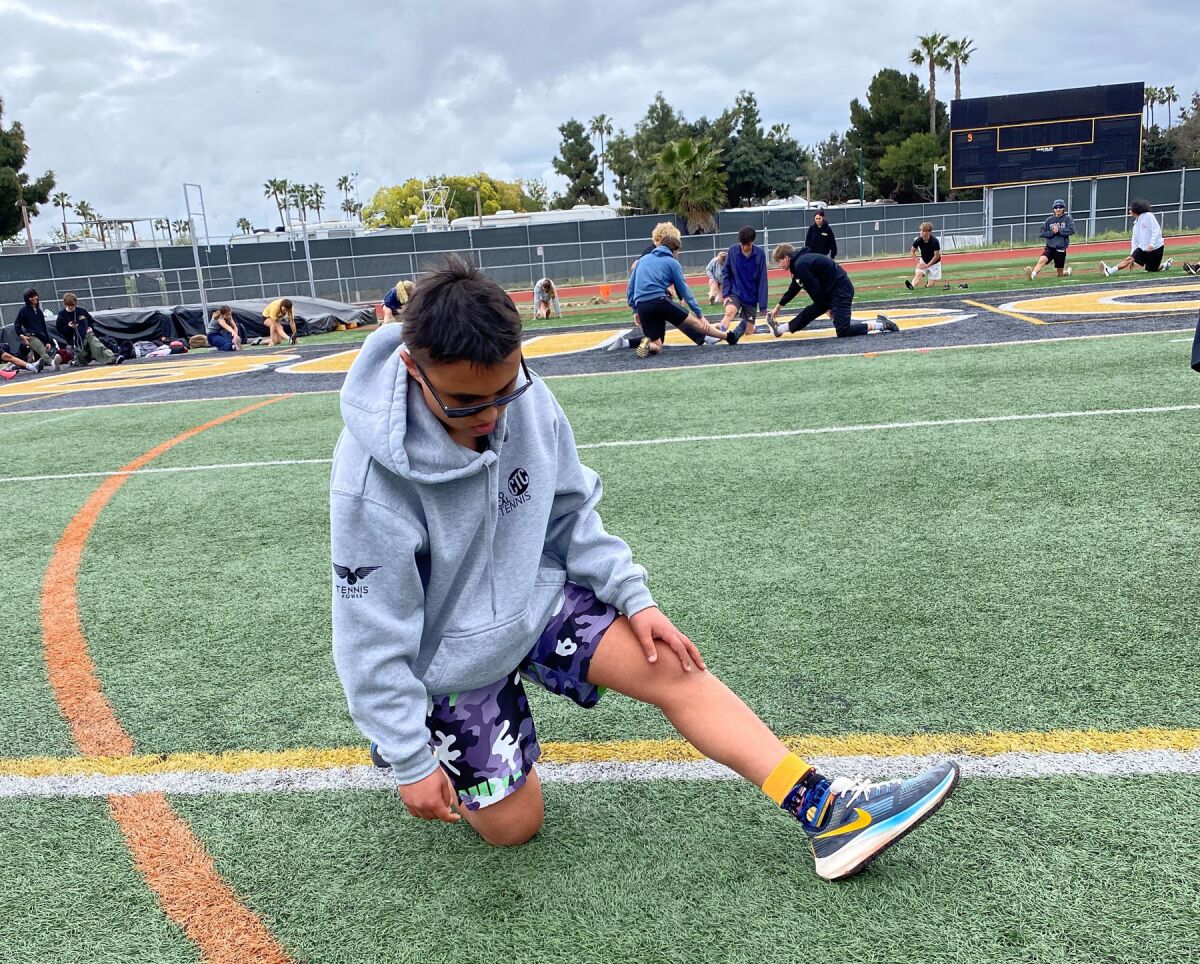 Freshman Chris Adamson stretching during track practice at Mission Bay High School.