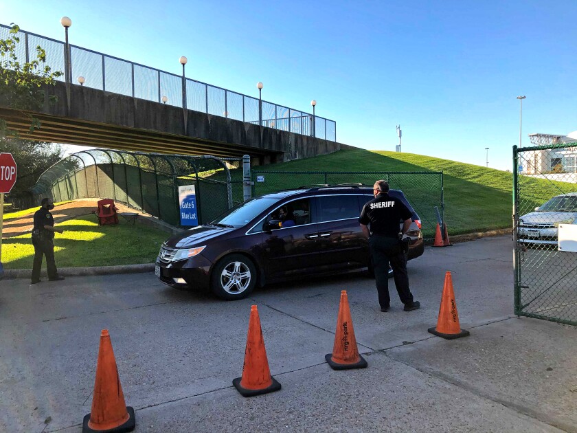 Houston police and a sheriff's deputy direct voters as they leave a drive-by polling place