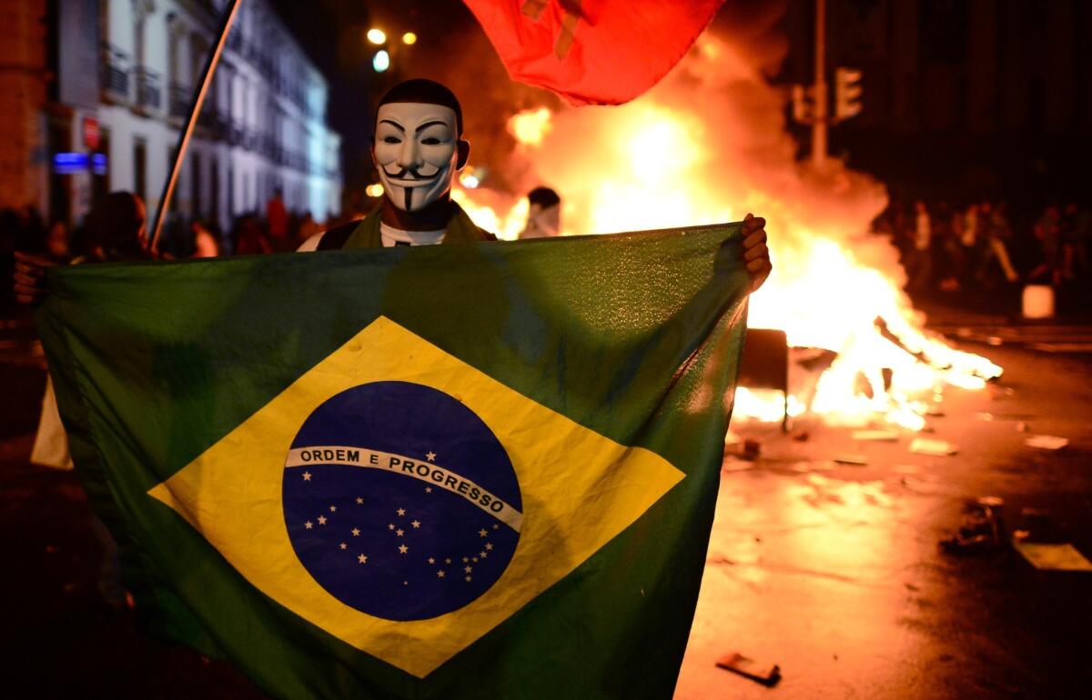 A demonstrator holds a Brazilian national flag during clashes in downtown Rio de Janeiro.