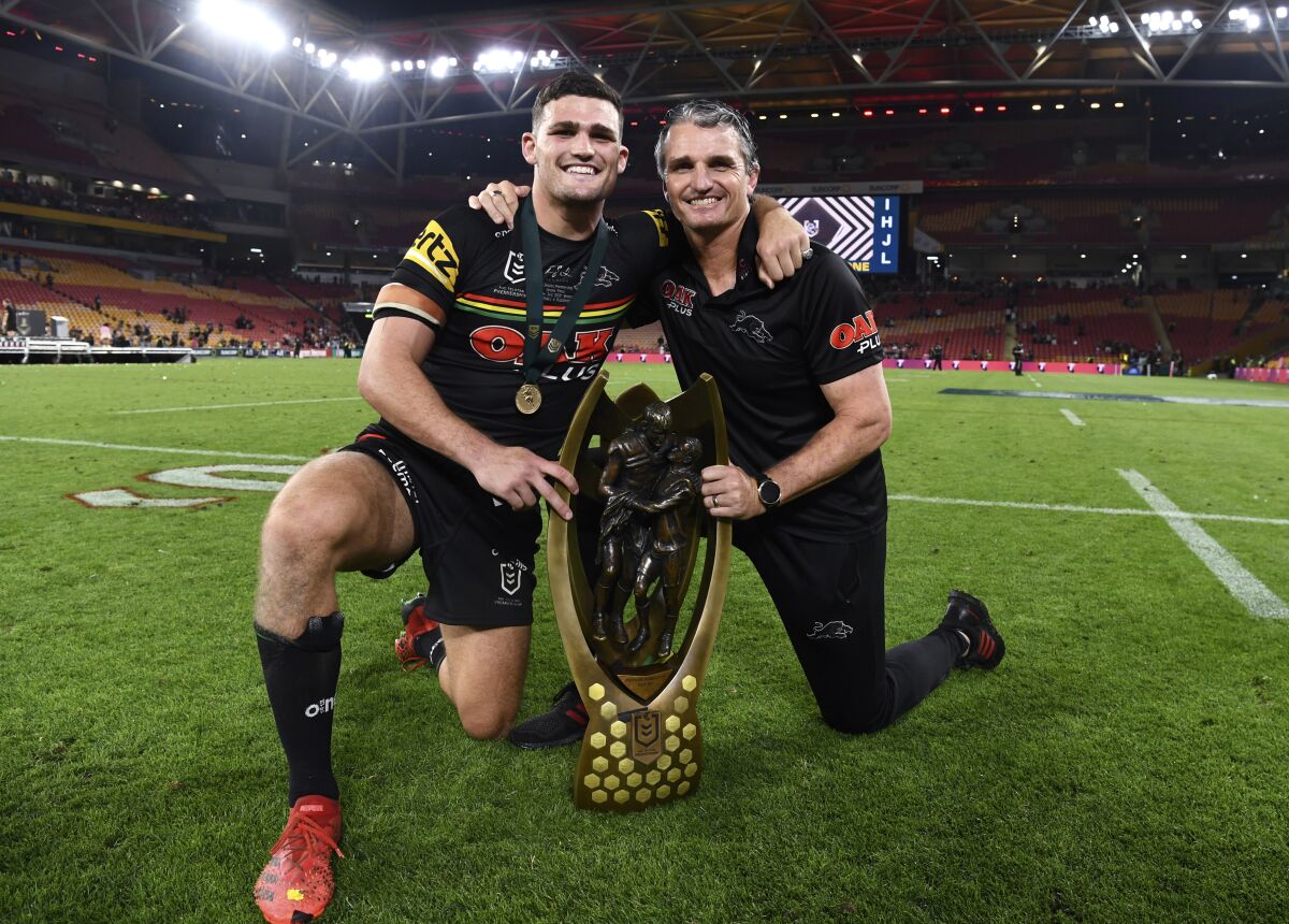 Nathan Cleary, left, and Ivan Cleary of the Penrith Panthers pose for a photograph following the National Rugby League grand final between the Panthers and South Sydney Rabbitohs in Brisbane, Sunday, Oct. 3, 2021. Ivan won a NRL grand final for the first time after two previous defeats as a coach and his son Nathan was named the player-of-the match as the Panthers beat the Rabbitohs 14-12 in the championship match at Brisbane. (Dave Hunt/AAP Image via AP)
