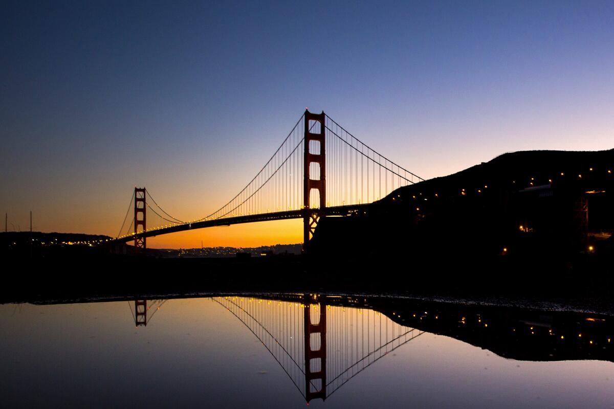 Golden Gate Bridge in silhouette at sunset.