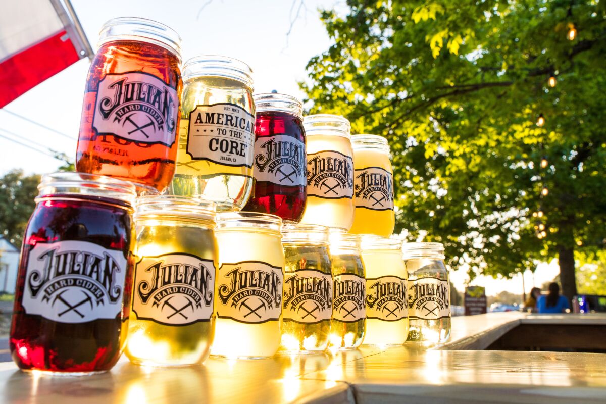 12 ciders of various colors in jars stacked on top of each other in two rows with "Julian Hard Cider" labels