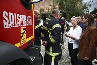 French Prime Minister Elisabeth Borne, 2nd right, talks with a firefighter taking part in the rescue operations after a fire erupted at a holiday home for disabled people in Wintzenheim, France, Wednesday, Aug. 9, 2023. Eleven people have died after a fire ripped through a vacation home for adults with disabilities in eastern France. The deputy prosecutor of Colmar said 11 people who were sleeping on the upper floor and in a mezzanine area of the private accommodation were trapped by the fire, while five managed to escape. (Sebastien Bozon, Pool Photo via AP)