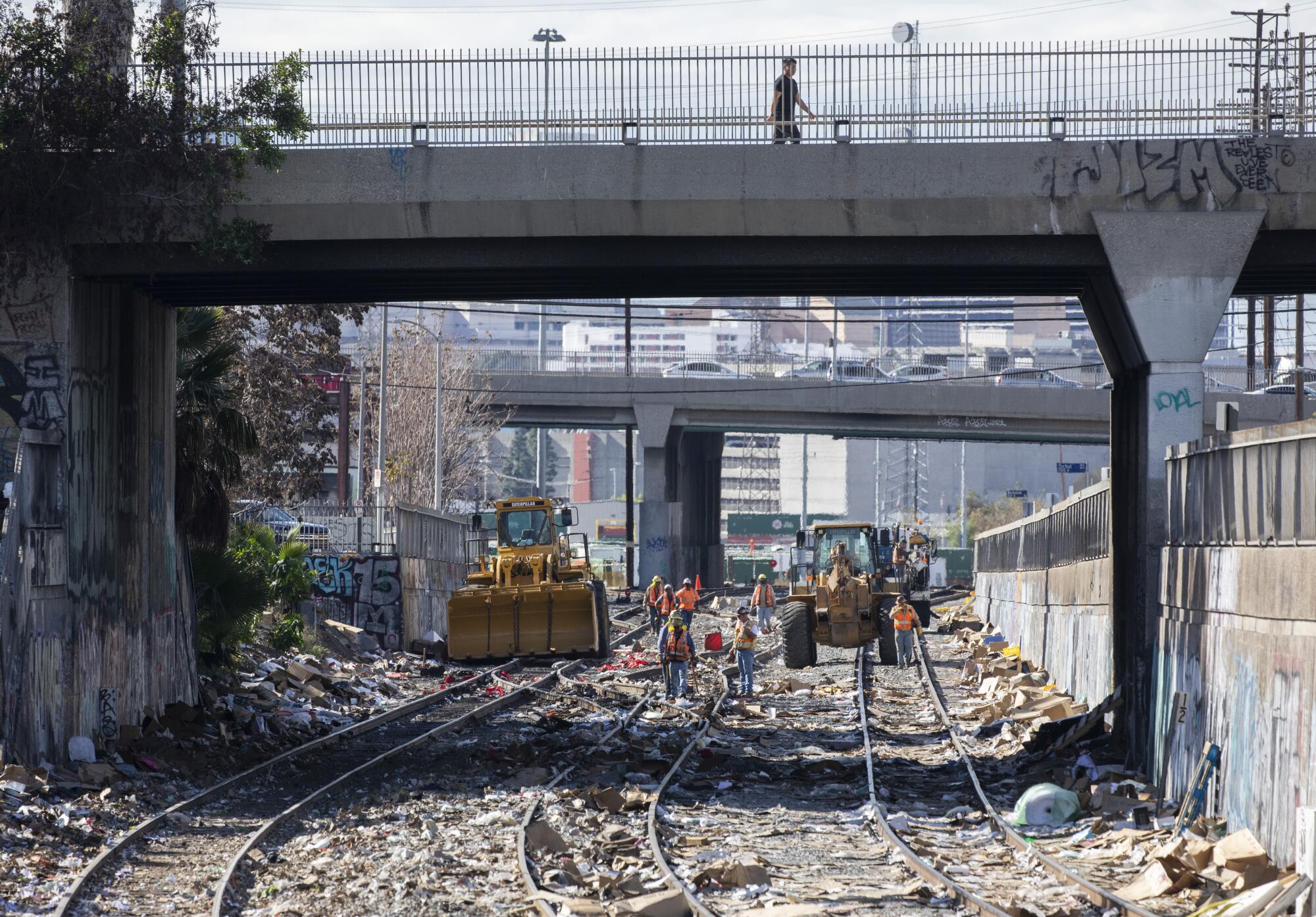 Crews repair a section of detached railroad track near downtown Los Angeles on Sunday.