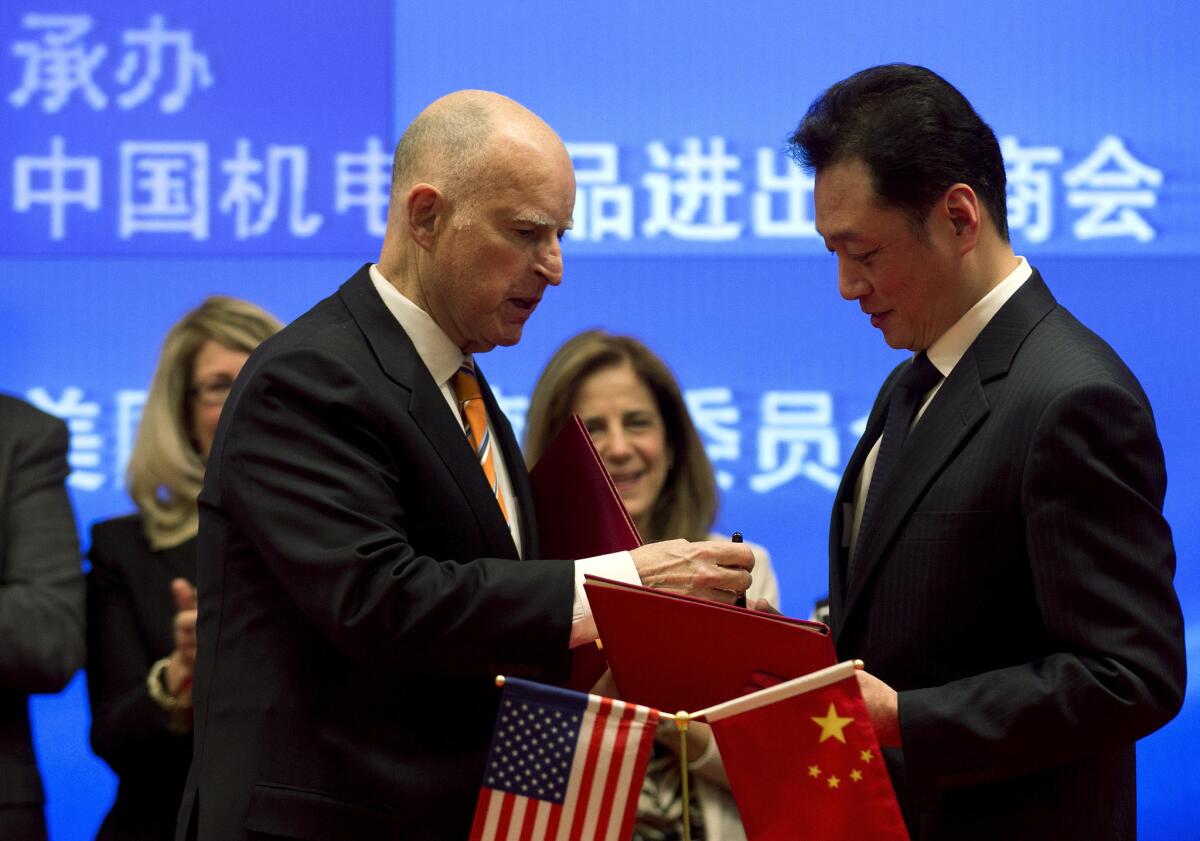 The environment has been a centerpiece of California Gov. Jerry Brown's week in China. Brown, left, exchanges a memorandum of understanding with Chinese Vice Minister of Commerce Wang Chao after a signing ceremony at a Beijing hotel.