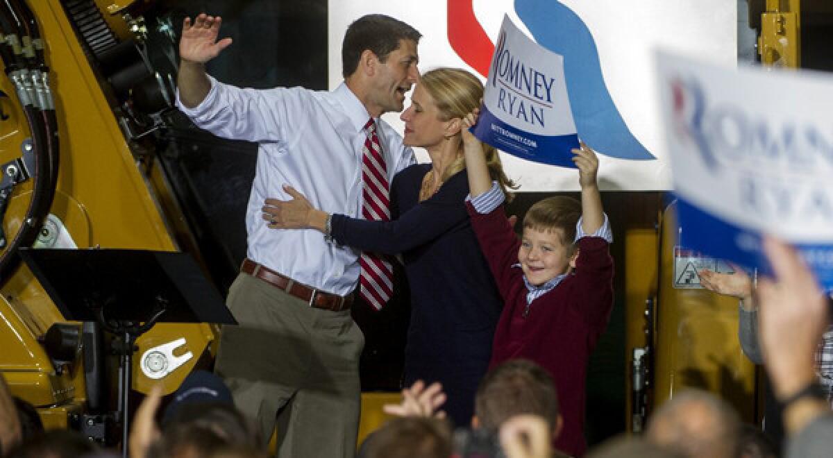 Republican vice presidential candidate Paul Ryan (R-Wis.) is greeted by his wife, Janna, and his son Charlie, holding a sign, after his campaign speech at the Gradall Industries plant in New Philadelphia, Ohio. Ryan is targeting women voters in the crucial swing state.