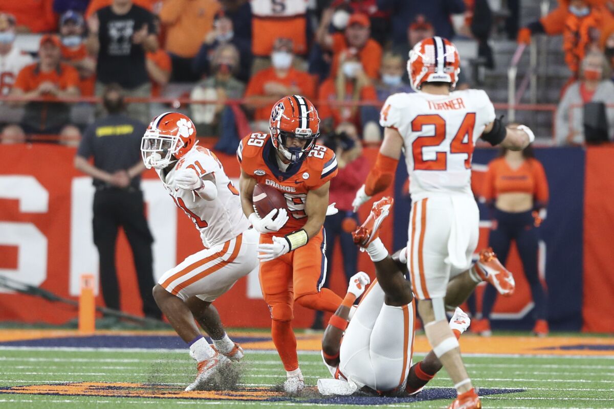 Syracuse wide receiver Trebor Pena (29) breaks through several Clemson defenders after a catch, on the way to a touchdown during the fourth quarter of an NCAA football game in Syracuse, N.Y., Friday, Oct. 15, 2021. (AP Photo/Joshua Bessex)