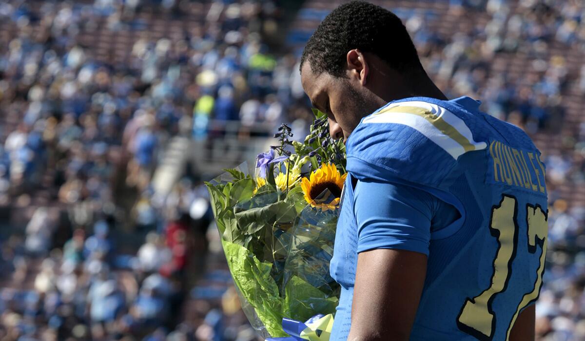 UCLA quarterback Brett Hundley stops to smell the sunflower as he participates in Senior Day ceremonies before the game against Stanford.