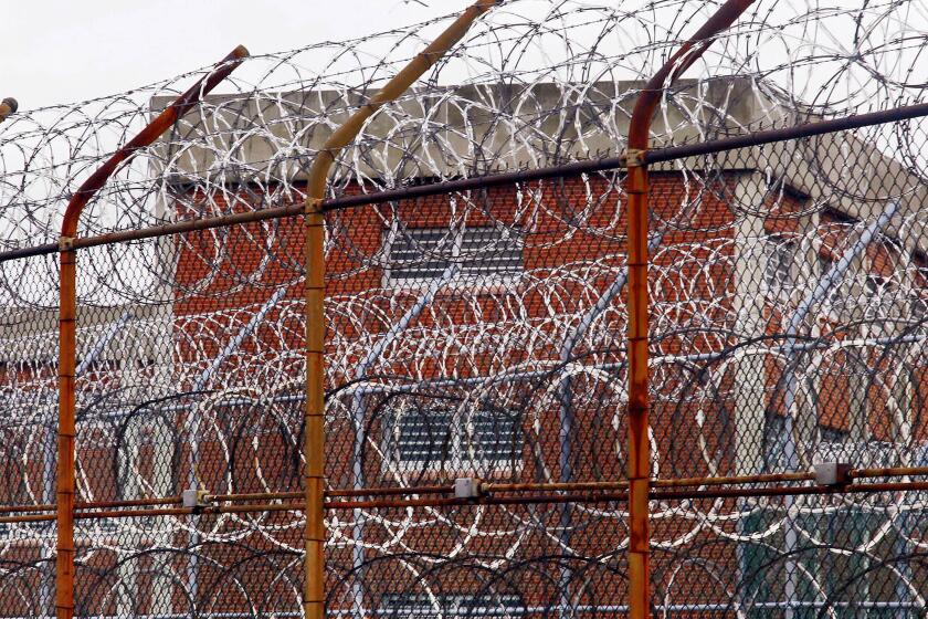 FILE - In this March 16, 2011, file photo, a security fence surrounds inmate housing on the Rikers Island correctional facility in New York. As of Wednesday, May 6, 2020, more than 20,000 inmates have been infected by the COVID-19 coronavirus and 295 have died nationwide, at Rikers Island and at state and federal lockups in cities and towns coast to coast, according to an unofficial tally kept by the COVID-19 Behind Bars Data Project run by UCLA Law. (AP Photo/Bebeto Matthews, File)