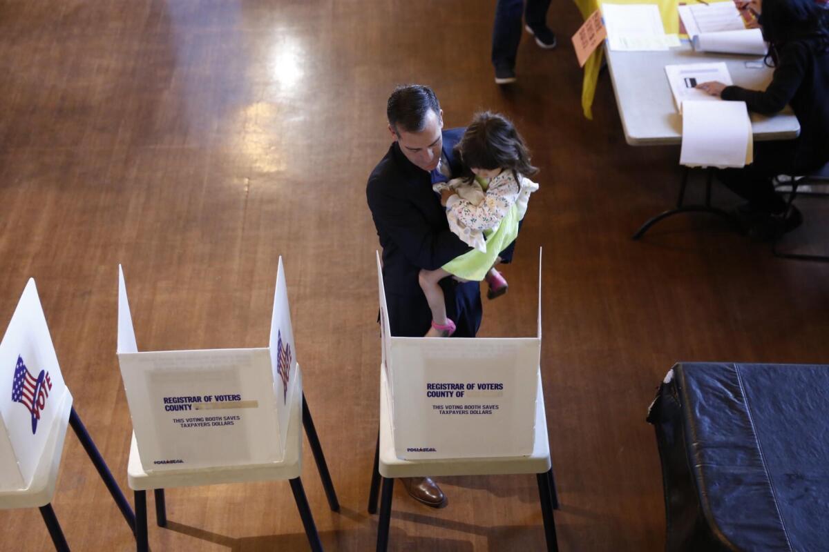 Los Angeles Mayor Eric Garcetti holds his daughter, Maya, 5, while casting his ballot at Wilshire United Methodist Church in Los Angeles.