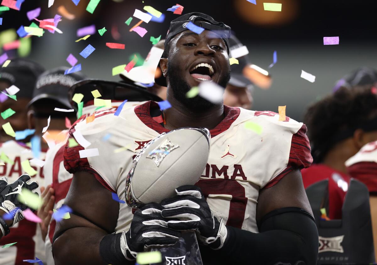 Oklahoma defensive tackle Neville Gallimore celebrates with the Big 12 Championship trophy.