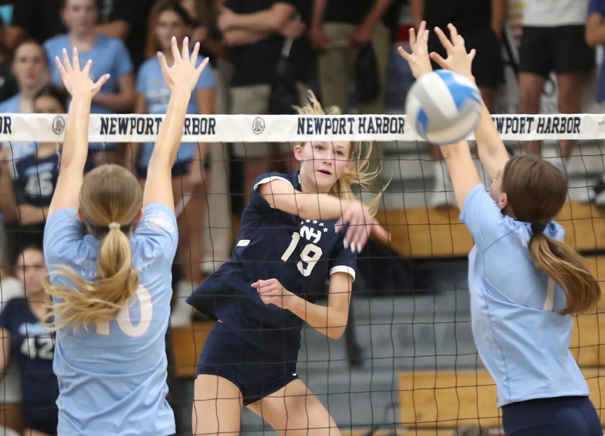 Newport Harbor's Piper Coady (19) puts a kill past Corona del Mar.