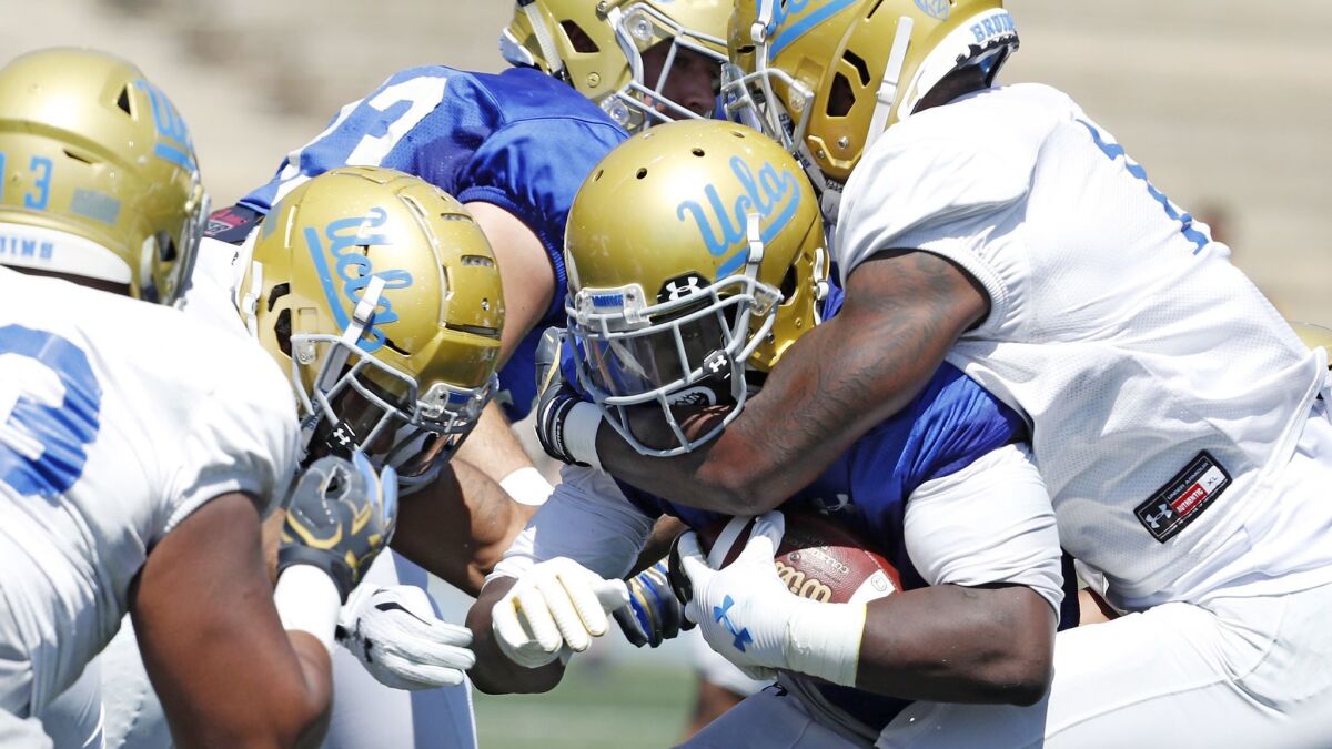UCLA running back Bolu Olorunfunmi is brought down during the Bruins' spring football game at Drake Stadium.