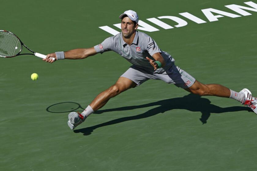Novak Djokovic stretches to return a shot during his semifinal victory over John Isner at the BNP Paribas Open in Indian Wells on Saturday. Djokovic will play Roger Federer in the tournament final Sunday.