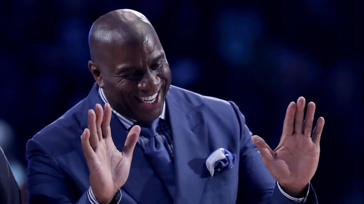 Magic Johnson is introduced at halftime of the NBA All-Star game on Feb. 17 in Charlotte, N.C. At work, says Christina M. Francis, Johnson "lives and breathes business."