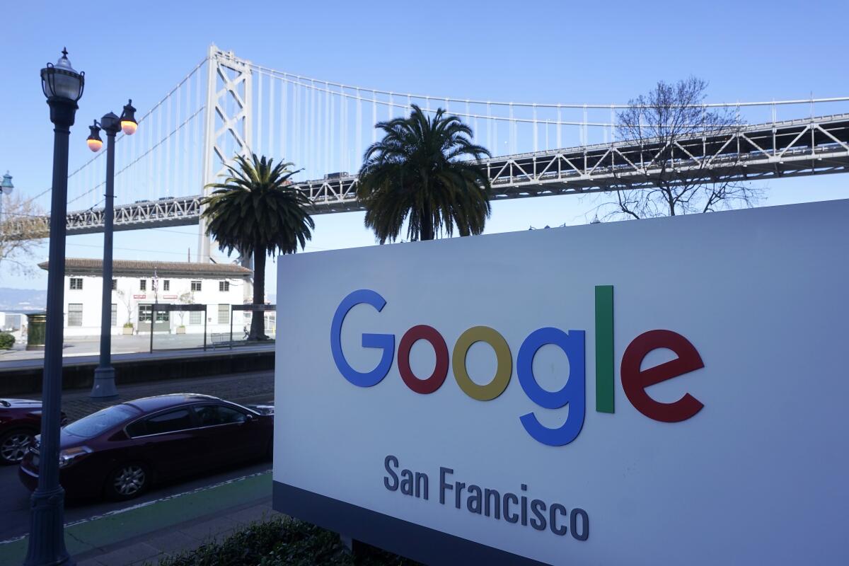 The San Francisco-Oakland Bay Bridge  behind a Google sign at the company's office in San Francisco.