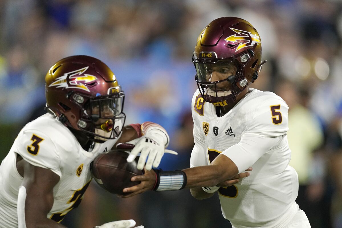Arizona State quarterback Jayden Daniels, right, hands off to running back Rachaad White during the first half of an NCAA college football game against UCLA Saturday, Oct. 2, 2021, in Pasadena, Calif. (AP Photo/Mark J. Terrill)