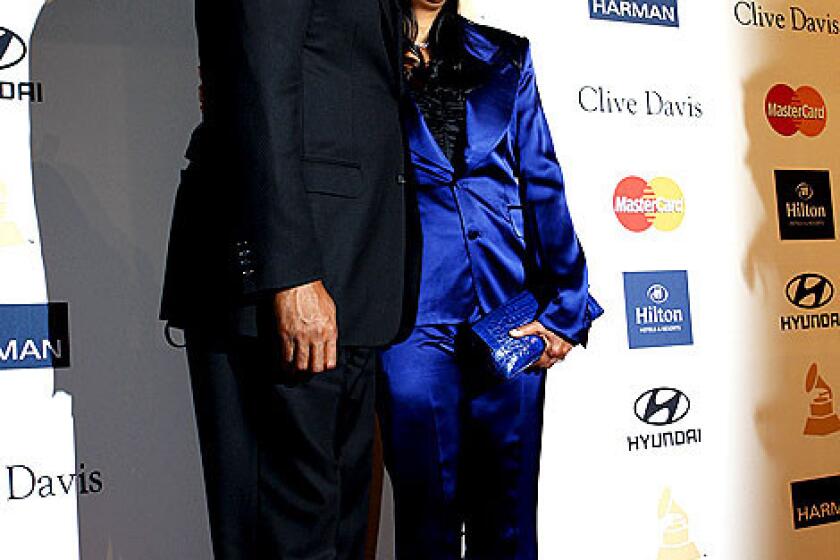 Magic Johnson with wife Cookie pose on the red carpet.