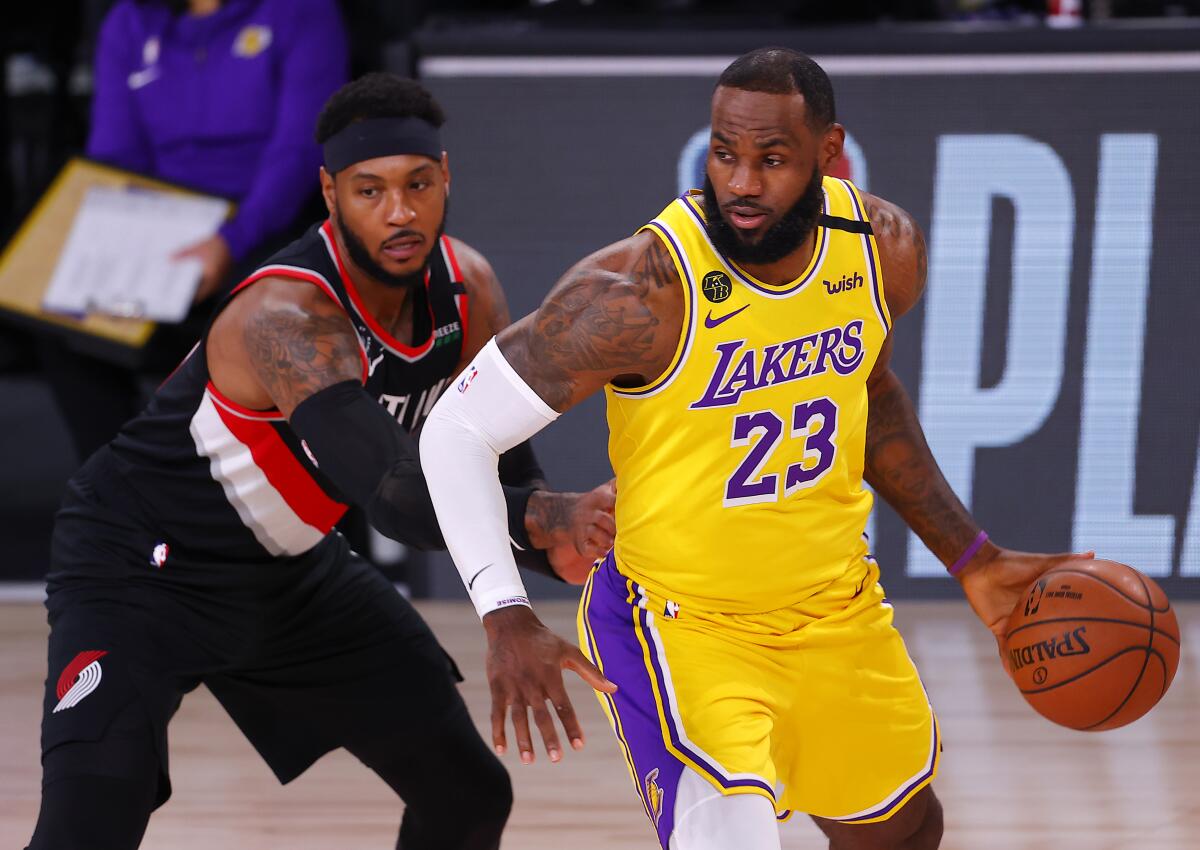 Lakers star LeBron James, right, drives on Portland's Carmelo Anthony during Tuesday's game.