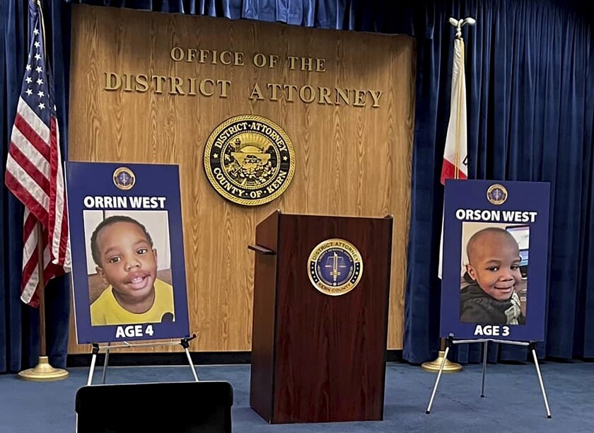This photo provided by the Kern County District Attorney's Office from their Facebook page from a video news conference feed, shows photos displayed of Orrin West and Orson West prior to a news conference by Kern County District Attorney Cynthia Zimmer to discuss recent developments in the case involving the two brothers on Wednesday, March 2, 2022 in Bakersfield, Calif. The adoptive parents of the boys who were reported missing in 2020 have been charged with killing their children, although their bodies have not been found, authorities said Wednesday. (Kern County District Attorney's Office via AP)