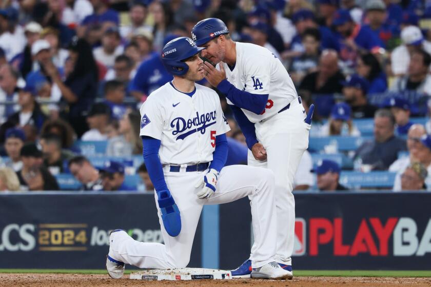 LOS ANGELES, CALIFORNIA - OCTOBER 13: Freddie Freeman #5 of the Los Angeles Dodgers talks with first base coach Clayton McCullough after a single during the third inning in game one of the National League Championship Series against the New York Mets at Dodger Stadium on Sunday, Oct. 13, 2024 in Los Angeles. (Robert Gauthier / Los Angeles Times)