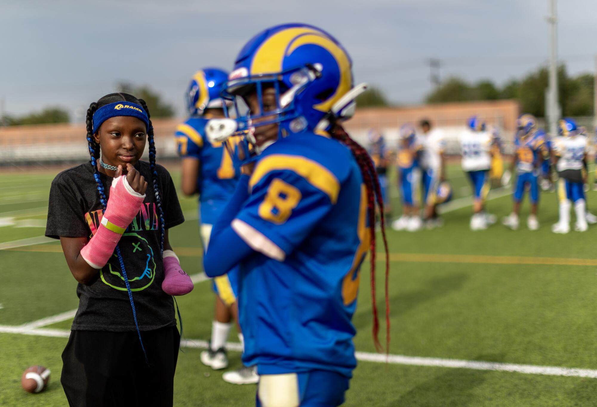 With both arms fitted with casts, La'Veyah Mosley, 12, left, watches her twin sister La'Viyah 