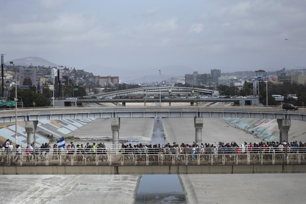 Central Americans walk toward the U.S. border in Tijuana to request asylum.