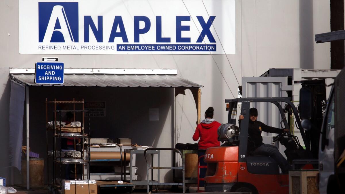 Employees at the Anaplex Corp. in Paramount. The metal plant is one of two ordered by L.A. County health officials to stop endangering the health of the public.