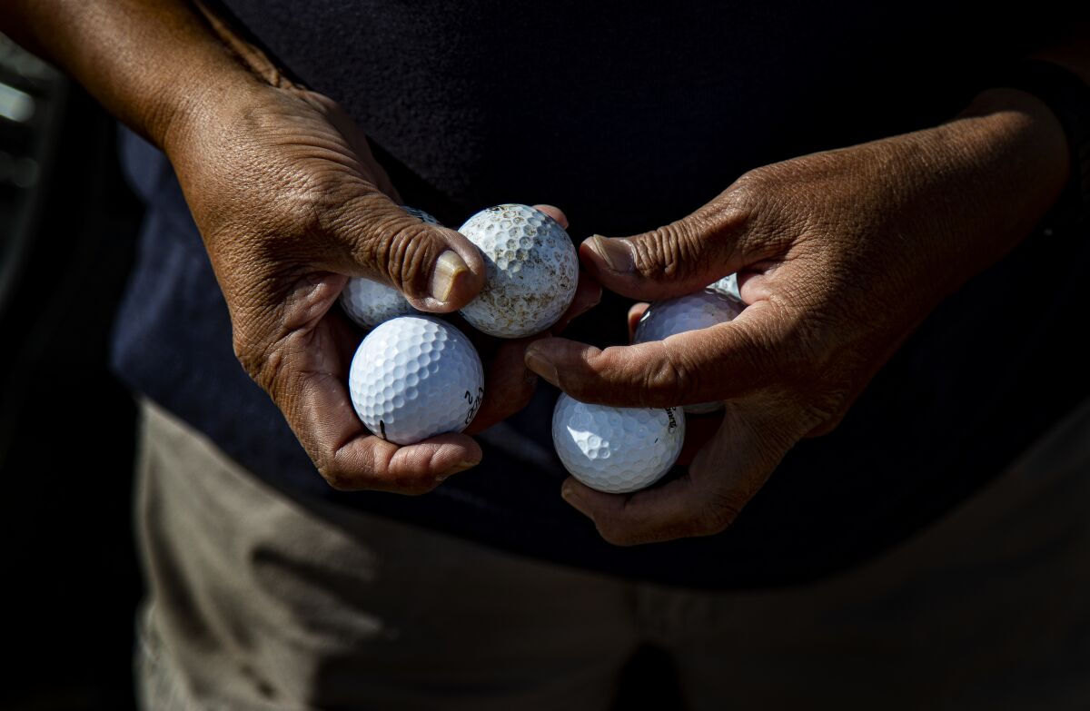 Man holds golf balls.