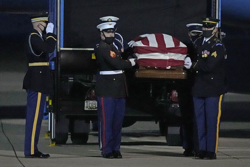 A joint services military bearer team moves the casket of former Sen. Bob Dole, R-Kan., after arriving at the airport in Salina, Kan., Friday, Dec. 10, 2021. (AP Photo/Charlie Riedel)
