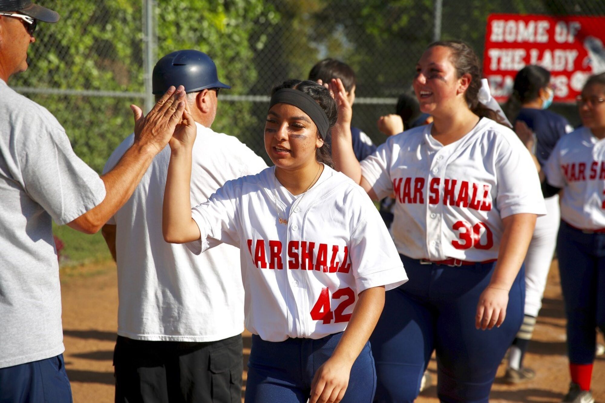 Marshall seniors Gabriela Aguilar and Rosie Agdaian lead the team's handshake line after their final home game.
