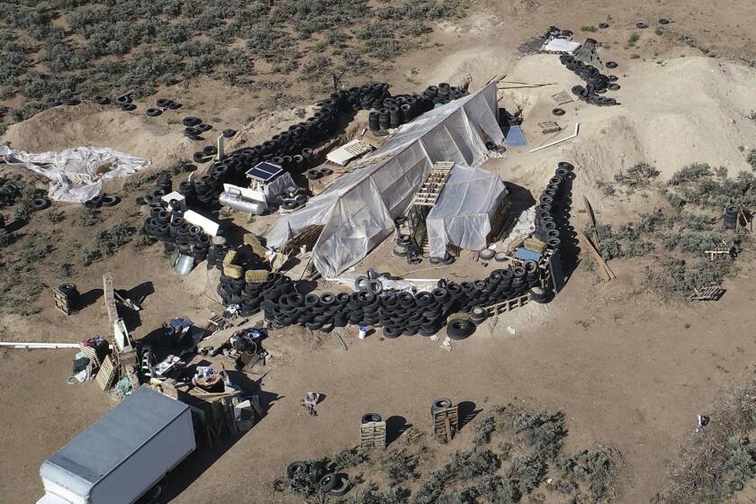 FILE - A ramshackle compound is seen in the desert area of Amalia, N.M., on Aug. 10, 2018. Two firearms charges were dismissed Thursday, Sept. 21, 2023, amid preparations for trial against an extended family arrested in a 2018 law enforcement raid on the compound in northern New Mexico and the discovery of a young boy's decomposed body. (AP Photo/Brian Skoloff, File)