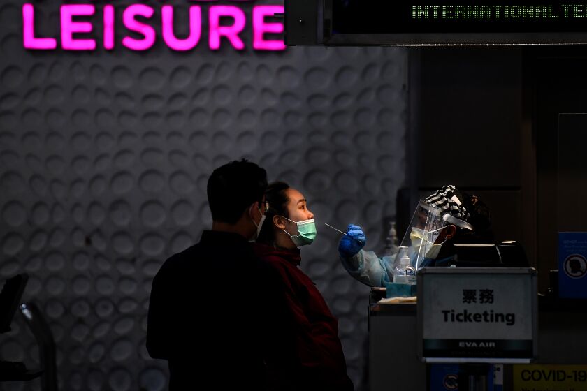 LOS ANGELES, CALIFORNIA DECEMBER 17, 2020-An airline passenger gets tested for COVID prior to a flight at the Tom Bradley International Terminal at LAX. (Los Angeles Times/Wally Skalij)