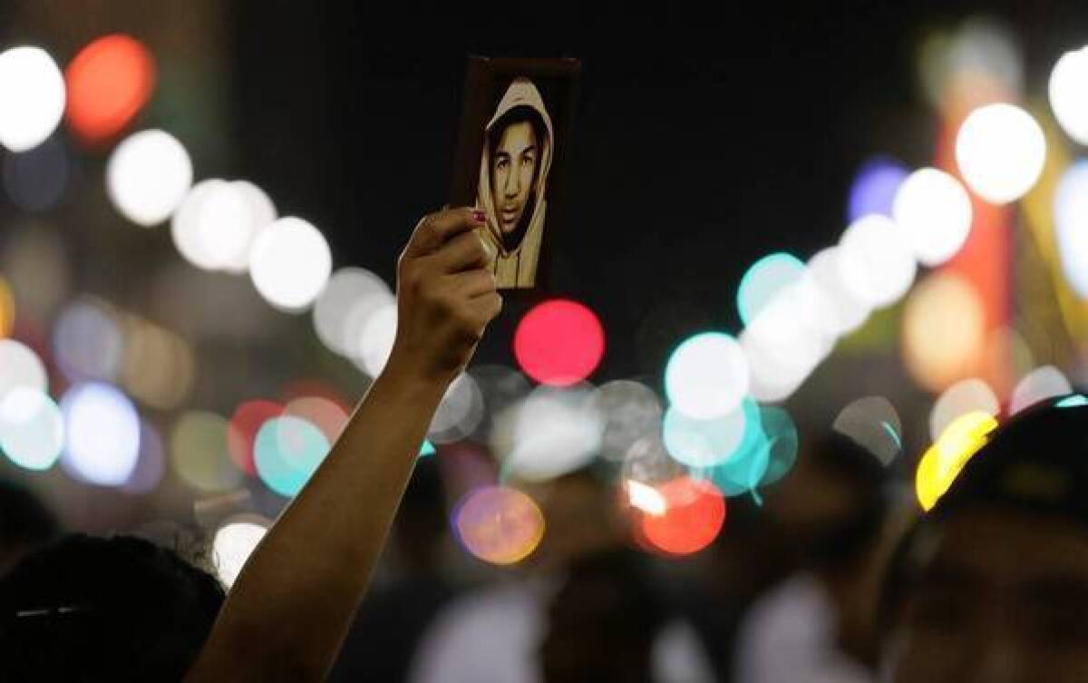 A protester carries a small photo of Trayvon Martin during a rally at Hollywood Boulevard and Highland Avenue after George Zimmerman was found not guilty in the Florida teen's death.