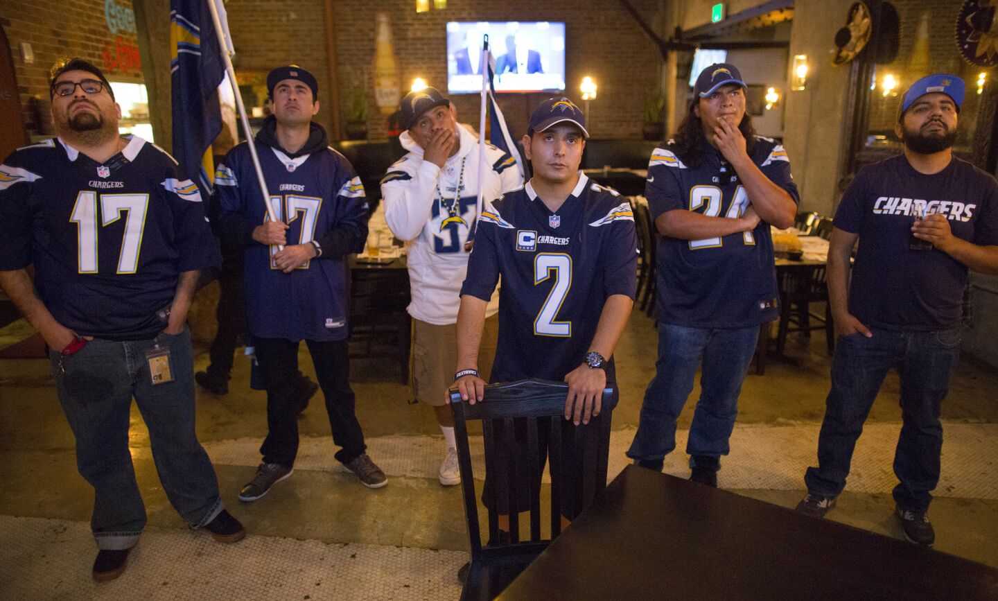 Los Angeles fans of the San Diego Chargers -- from left, Jorge Ponce, Angel Moreno, Erik Palacios, Micah Farias, Daniel Chavez and Arturo Hernandez -- react to news from the NFL owners meeting during a meet-up at El Compadre restaurant in L.A. on Jan. 12.