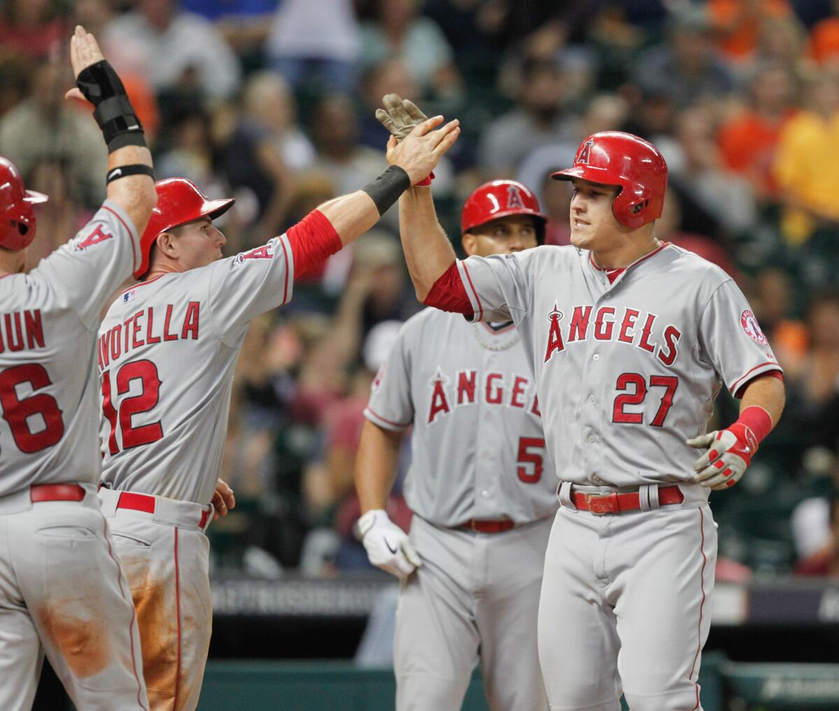 Angels center fielder Mike Trout (27) is congratulated by teammates after hitting a three-run home run in the eighth inning against the Astros on Friday night in Houston.