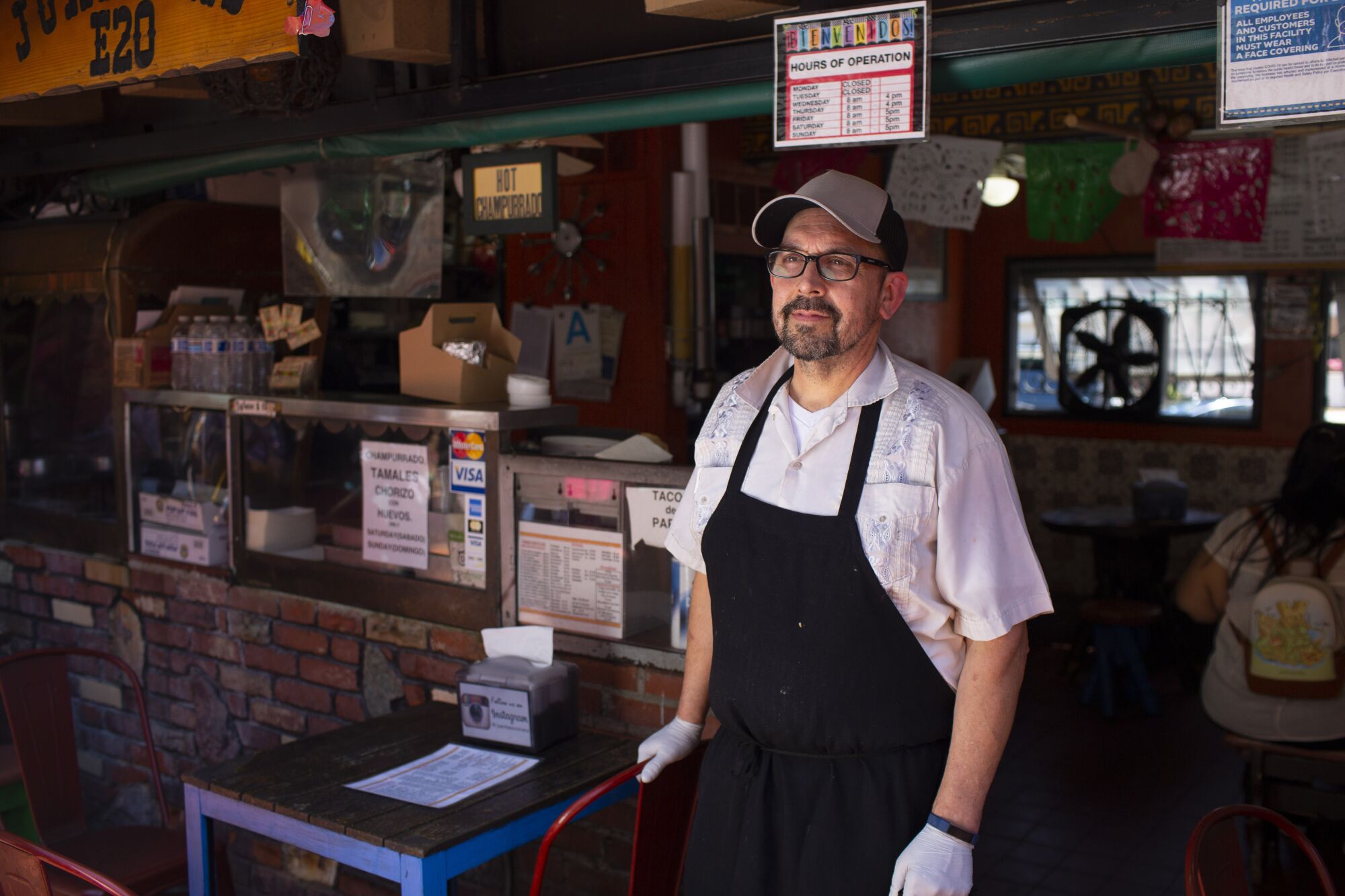 Edward Flores stands in front of a small Mexican cafe