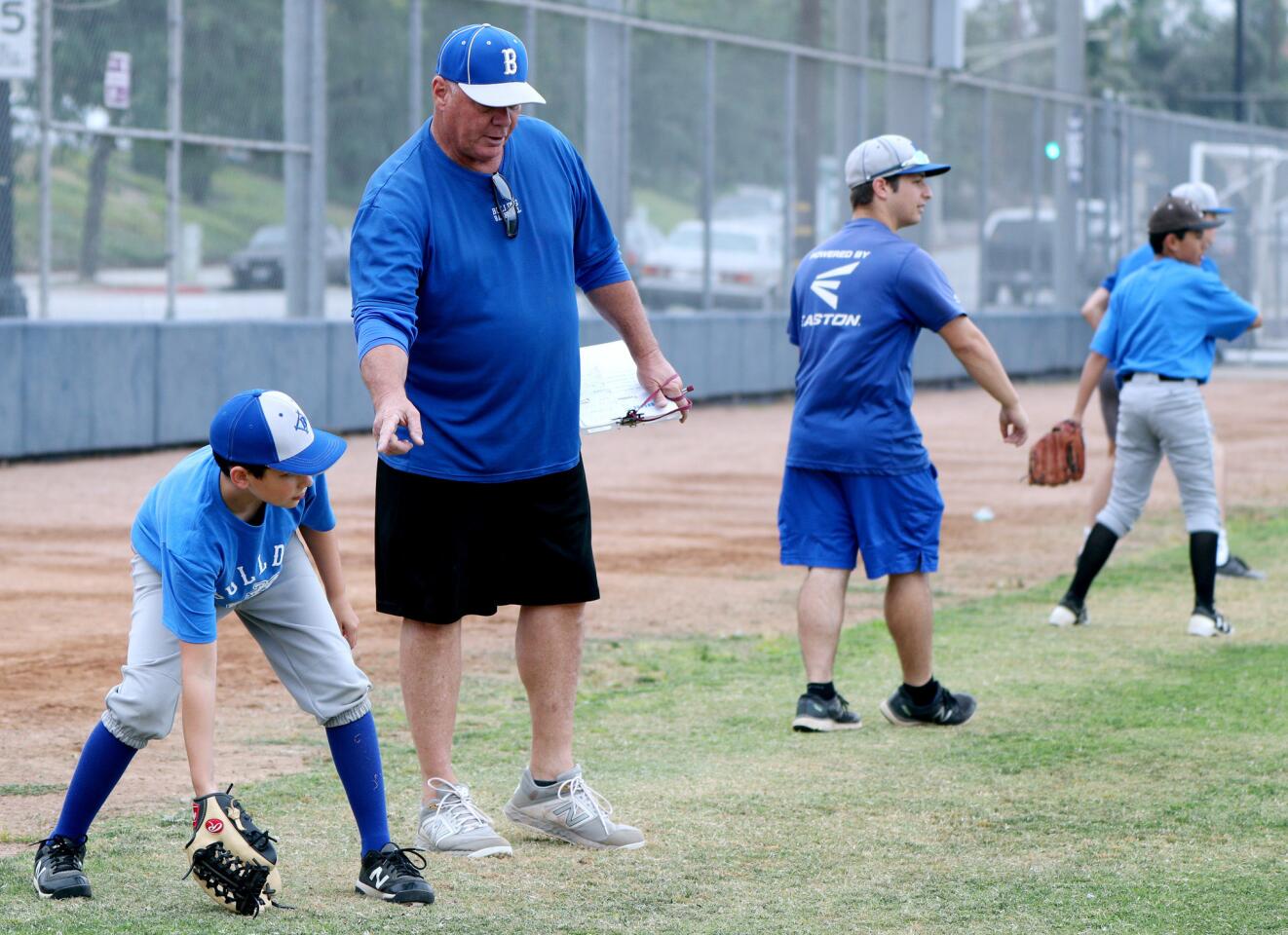 Burbank High School baseball coach Bob Hart instructs ten-year old Aidan Casey on the finer points of catching during the annual Junior Bulldogs Camp for youth 11-15, at Burbank High School on Tuesday, June 18, 2019.