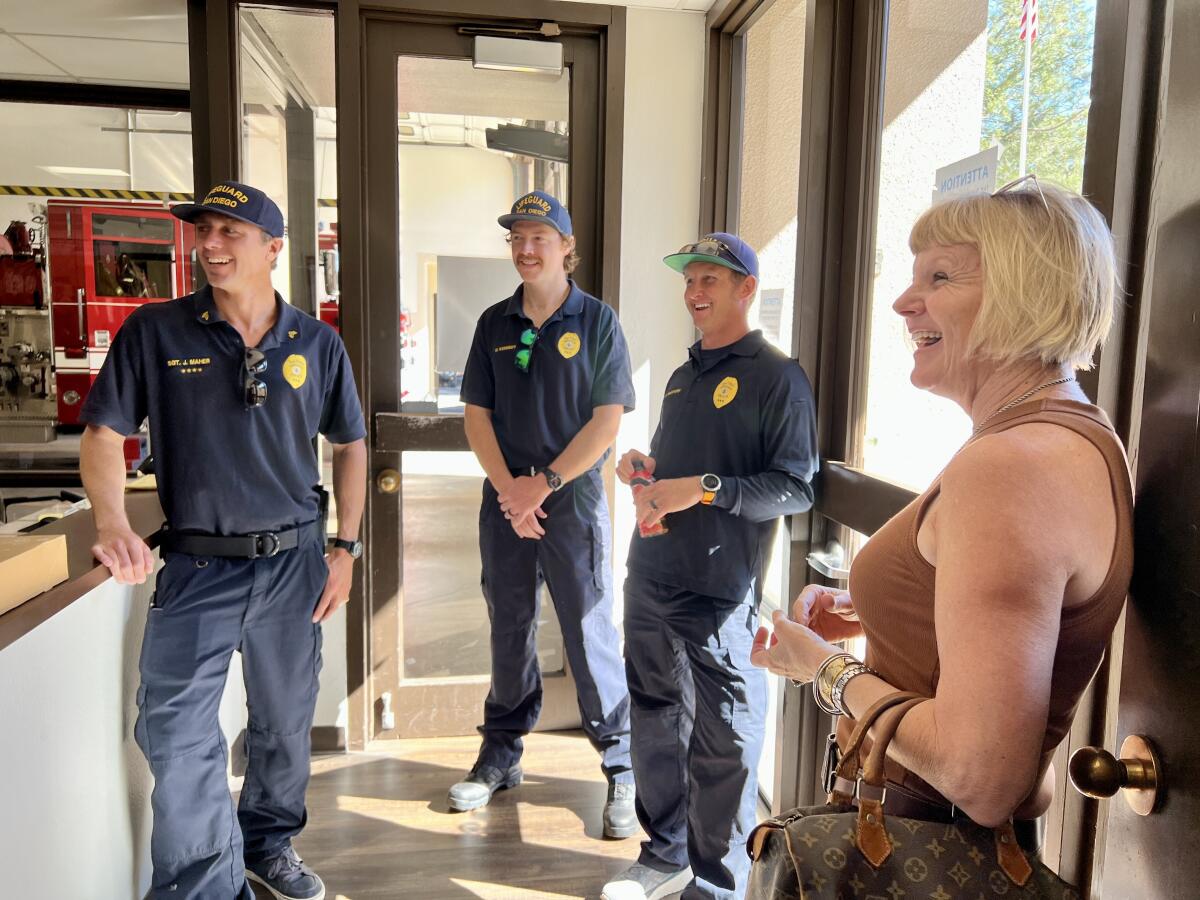 Margie Lord laughs with lifeguards who rescued her after she suffered broken vertebrae in a La Jolla surfing accident.