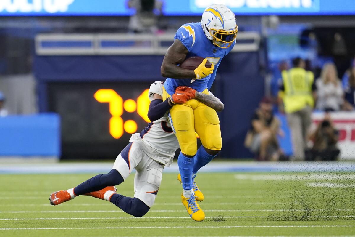 Chargers tight end Gerald Everett is hit by Denver Broncos safety Justin Simmons after making a catch in the second half.