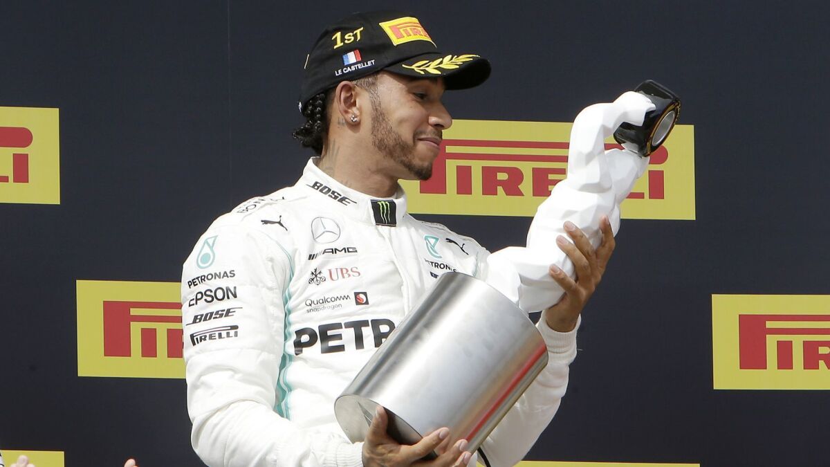 Mercedes driver Lewis Hamilton examines his trophy after winning the French Grand Prix on Sunday.