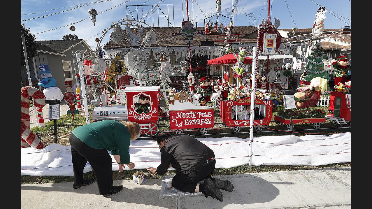 Pamela and Richard Norton work across their front yard pounding nails into snow-like fabric in the front of their yard of Christmas decorations in Burbank on Monday, December 4, 2017. The Norton's have had a display in their front yard for 48 years, forty-four of them with Christmas decorations. The final touches are being done today, and will open tonight.