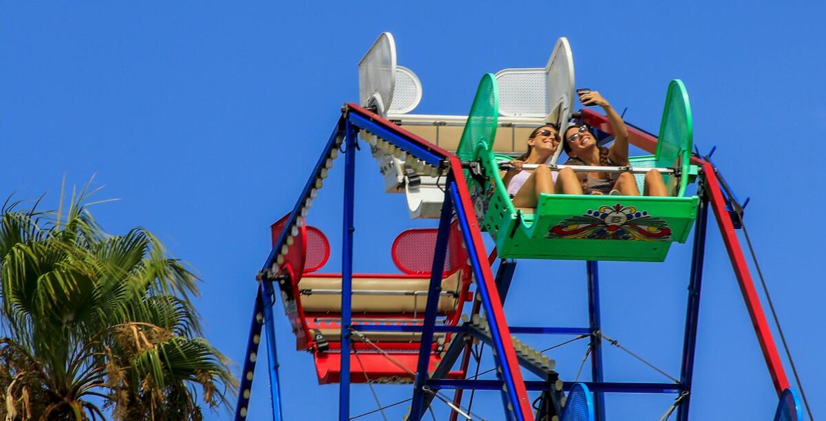 Riders at Newport Beach's Balboa Fun Zone in 2019. Health experts warned more young people are getting ill with COVID-19. 